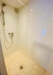 a bathroom with a shower with a tile floor at Brasserie & Logies De Pijl in Mechelen
