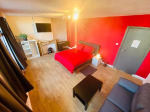 a red bedroom with a red bed and a couch at Brasserie & Logies De Pijl in Mechelen