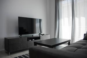 PaphosにあるRenovated one bedroom apartment in Paphos with poolのリビングルーム(薄型テレビ、ソファ付)