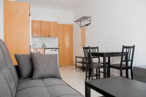 a living room with a couch and a table and a kitchen at Renovated one bedroom apartment in Paphos with pool in Paphos +8 photos