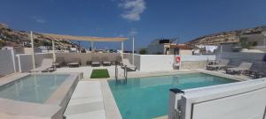 a large swimming pool with chairs and avisor at Antonios 1 in Matala