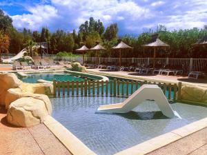 a swimming pool with a slide in the water at Camping La Pinède in Calvi