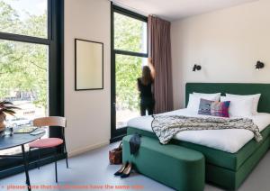 a bedroom with a bed and a green couch at Hotel Unplugged in Rotterdam