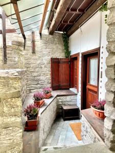 een veranda met potplanten op een stenen muur bij Courmayeur La Maison des Amis in Courmayeur