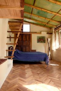 een slaapkamer met een bed en een houten vloer bij Avalon Hostal Boutique in Vilcabamba