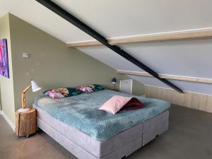 een slaapkamer met een groot bed op zolder bij Luxe Loft voor 4 personen in Reutum