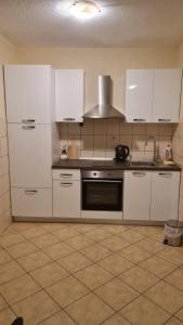 a kitchen with white cabinets and a stove at Apartments Prižmić in Podstrana