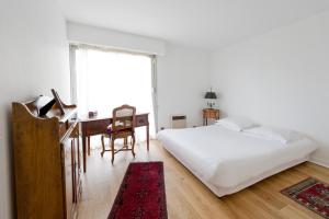 Un dormitorio con una cama y un escritorio y una ventana. en L'appart Beaubadat, en Burdeos