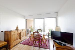 sala de estar con TV y mesa con sillas en L'appart Beaubadat, en Burdeos