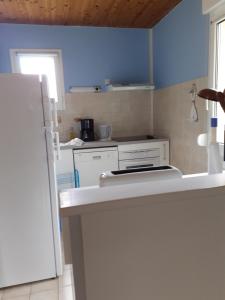uma cozinha com electrodomésticos brancos e uma parede azul em Maison vacances d'Oléron em La Brée-les-Bains