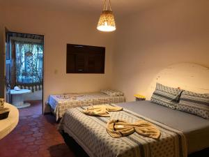1 dormitorio con 2 camas y toallas. en Pousada o Mineiro Central, en Galinhos