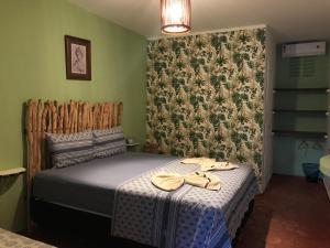 a bedroom with a bed with flip flops on it at Pousada o Mineiro Central in Galinhos