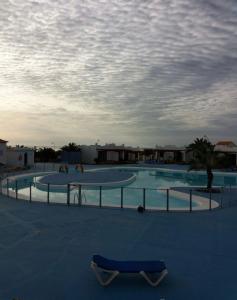 a swimming pool with two trays and a skateboard on the ground at Sun Beach 5 in Caleta De Fuste