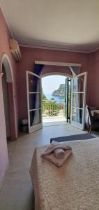 a bedroom with a bed and a view of the ocean at Paleo Inn Hotel in Paleokastritsa