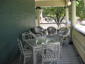 une table et des chaises assises sur une terrasse couverte dans l'établissement Bayberry House Bed and Breakfast, à Steubenville