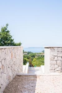 a stone wall with a view of the ocean at Encanto Agriturismo & Private SPA in Visogliano