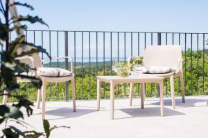 two chairs and a table on a balcony at Encanto Agriturismo & Private SPA in Visogliano