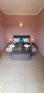 sypialnia z dużym łóżkiem z dwoma stołami w obiekcie Paleo Inn Hotel w mieście Paleokastritsa