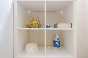 a white book shelf with a surfboard on it at Stay U-nique Apartments Pasteur in Barcelona