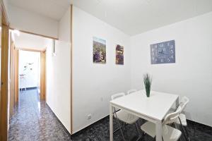 - une salle à manger blanche avec une table et des chaises blanches dans l'établissement Stay U-nique Apartments Tapioles, à Barcelone