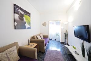 sala de estar con sofá y TV en Stay U-nique Apartments Tapioles en Barcelona