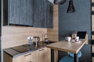 uma cozinha com uma mesa de madeira e um lavatório em ApartStel em São Petersburgo