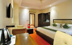um quarto de hotel com uma cama grande e uma secretária em Zenith Hotel - Delhi Airport em Nova Deli
