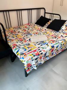 ein Bett mit einer bunten Decke darüber in der Unterkunft Next to the beach Mackenzie Studio in Larnaka
