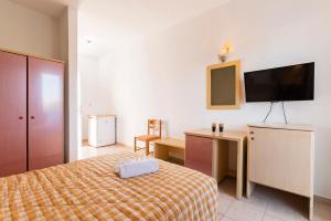 a bedroom with a bed and a desk and a tv at Summer View in Theologos