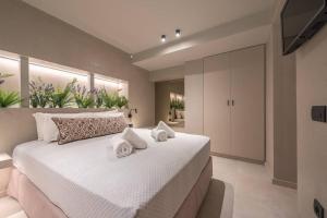 um quarto com uma grande cama branca com toalhas em Apollonos 28 Luxury Suites em Atenas