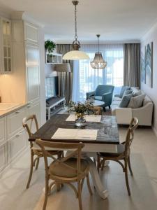 Una cocina y una sala de estar con mesa y sillas. en Luksusowy Apartament Blue11, en Międzyzdroje