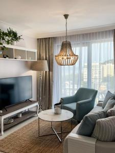 Una sala de estar con un sofá y un televisor. en Luksusowy Apartament Blue11, en Międzyzdroje