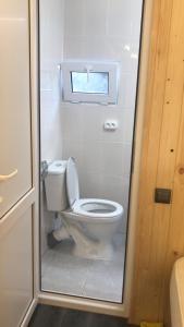 a bathroom with a white toilet with a window at Guest House Lory in Adler