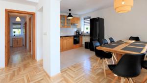 Apartament w Villa Konik Mazury في Rekownica: مطبخ وغرفة طعام مع طاولة وكراسي