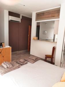 1 dormitorio con cama, silla y espejo en Casa Martín, en Ávila