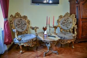 a room with two chairs and a table with two candles at History Apartments Cetății in Sibiu
