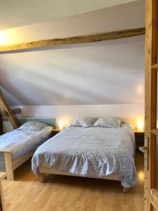 La Vove في Rouillon: سريرين في غرفة نوم مع مصباحين على الطاولات