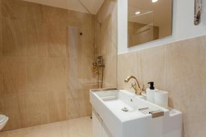 a bathroom with a white sink and a mirror at Boutique apartments - Central Old Town in Banská Štiavnica