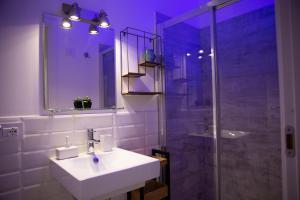 La salle de bains est pourvue d'un lavabo et d'une douche en verre. dans l'établissement Villa Volli Three Rooms, à Agrigente