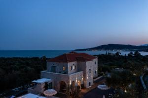 an old building with the ocean in the background at The Olive Yard in Gythio