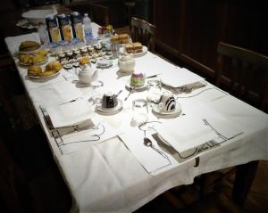 une table avec un tissu de table blanc et de la nourriture dans l'établissement Cascina Creusa B&B, à Pocapaglia