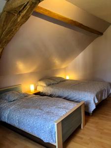 two beds in a bedroom with two lamps at La Vove in Rouillon