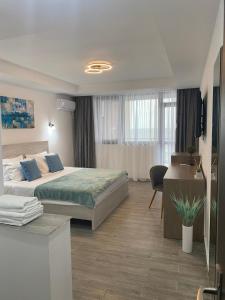 een slaapkamer met een bed en een bureau in een kamer bij Aqua Villa by the Sea in Eforie Sud