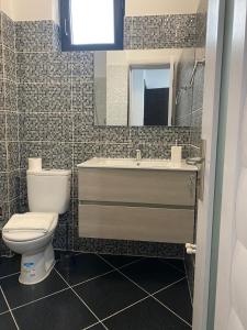 a bathroom with a toilet and a sink and a mirror at Aqua Villa by the Sea in Eforie Sud