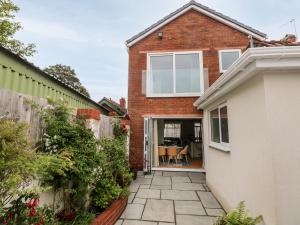 a brick house with a door open to a patio at The Headlands - Gower in The Mumbles