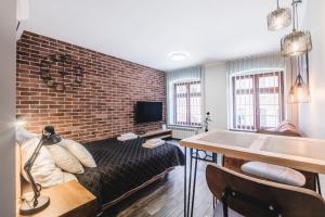 Televízia a/alebo spoločenská miestnosť v ubytovaní Apartamenty Świętego Jakuba