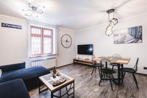 Televízia a/alebo spoločenská miestnosť v ubytovaní Apartamenty Świętego Jakuba
