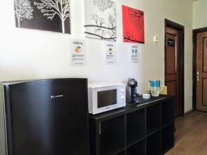 a kitchen with a black refrigerator and a microwave at Garden House Alla Torre in Isola delle Femmine