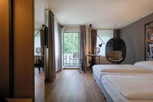 een hotelkamer met 2 bedden en een balkon bij Seminaris Hotel Bad Boll in Bad Boll