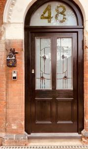 a brown door with a number on it at De Parys Guest House - Fully Airconditioned in Bedford
